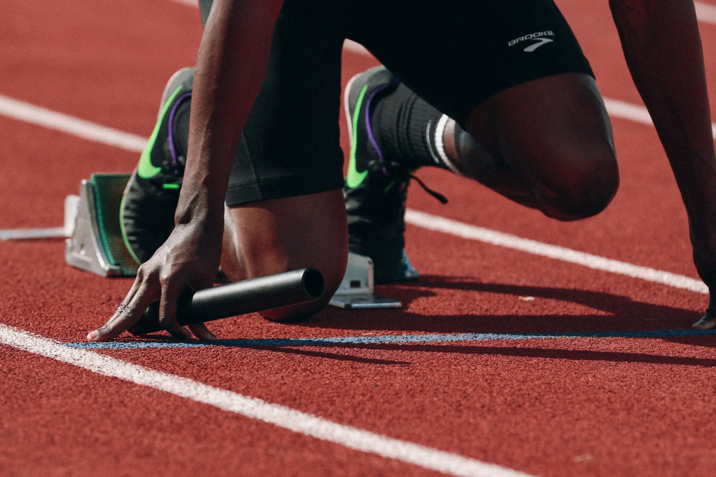 Atleta preparado en los tacos de salida sobre una pista de atletismo