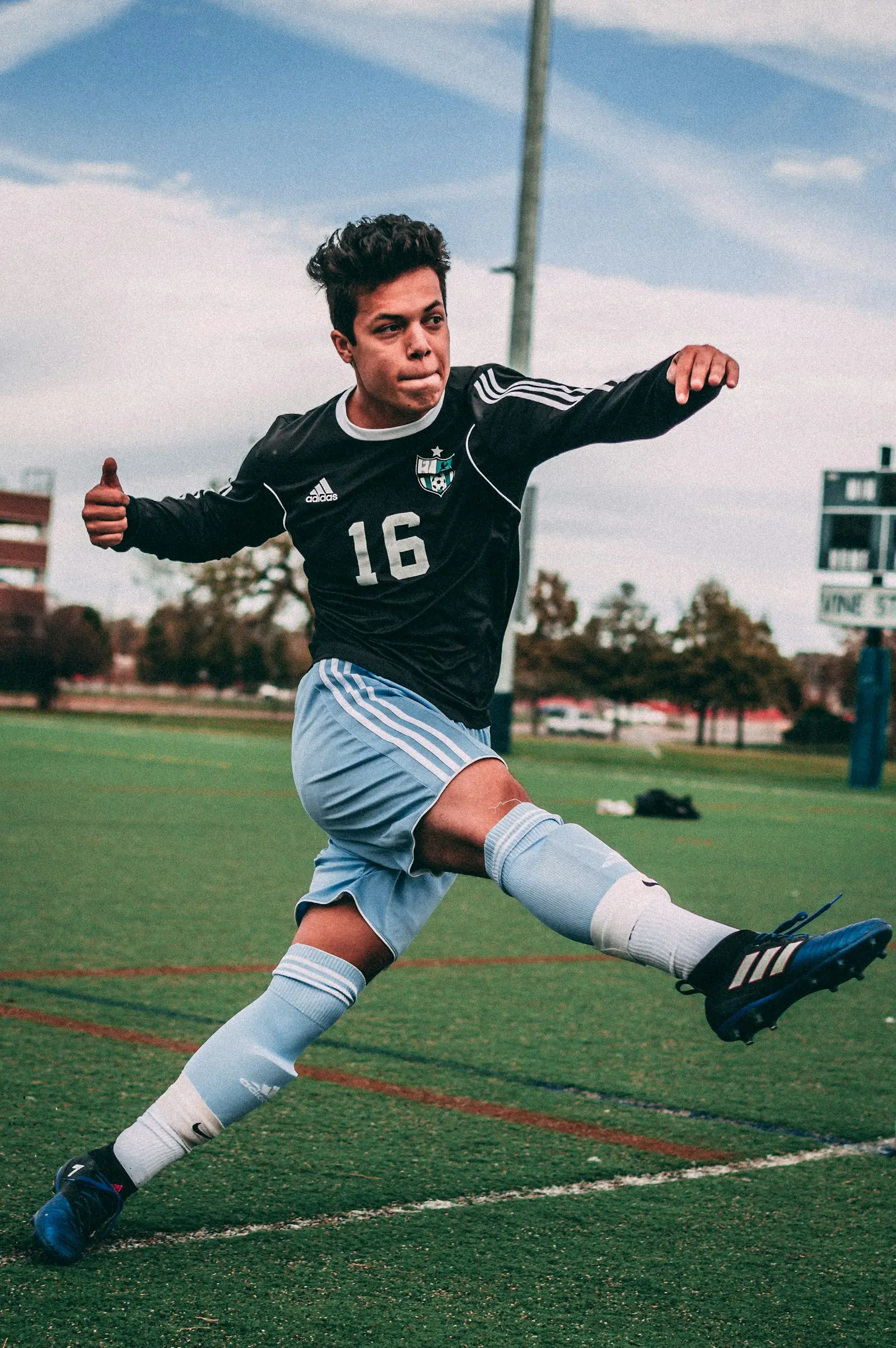 Joven futbolista golpeando el balón en un campo de césped